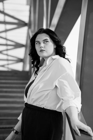 Business woman in black trousers and white shirt. Business lady in a black business suit against the background of a business centerの写真素材