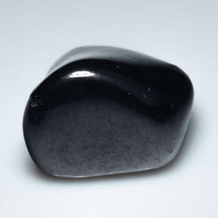 Elegantly Polished Shungite Gemstone on Pristine White Background.の写真素材