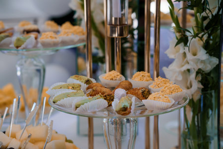 Elegant Dessert Buffet with Assorted Pastries and Floral Decor at Sophisticated Event.の写真素材