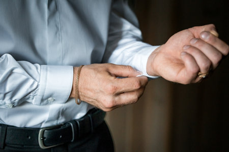 Elegant Close-Up of a Man Adjusting Shirt Cuff for Formal Attire Preparation.の写真素材