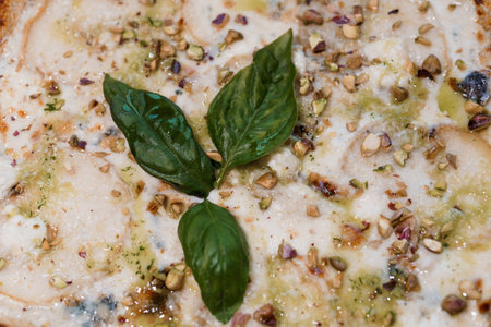 Gourmet White Pizza with Fresh Basil and Crunchy Nuts Topping.の写真素材