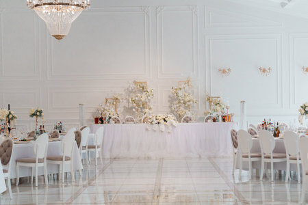 Elegant Wedding Reception Hall with Luxurious White Decor and Crystal Chandeliers.の写真素材