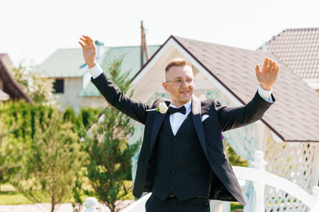 Joyful Groom Celebrating Outdoors in Elegant Tuxedo at Charming Rustic Venue.の写真素材