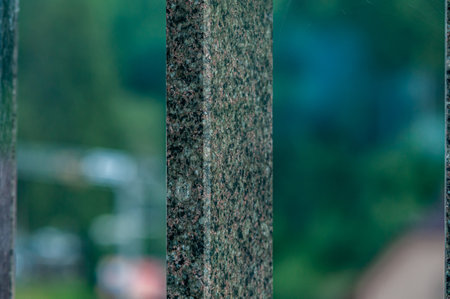Textured Granite Fence with Blurred Greenery Background.の写真素材
