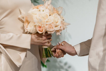 Romantic Wedding Moment with Bride Holding Bouquet and Groom's Hand in Elegant Ceremony.の写真素材