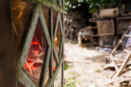 Rustic Charm of an Abandoned Garden Shed Framed by Stained Glass.の写真素材