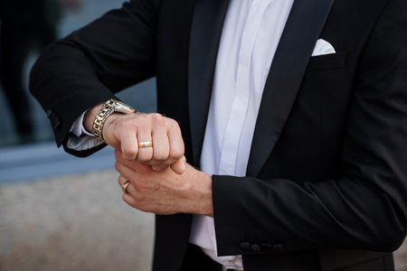 Elegant Groom Adjusting Cufflinks at Formal Event.の写真素材
