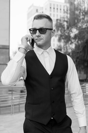 Stylish Young Executive in Modern Urban Setting Engaging in Conversation.