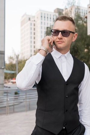 Stylish Businessman Talking on a Smartphone in Urban Setting.の写真素材