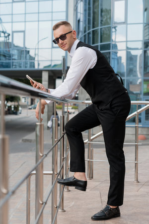 Stylish Businessman in Sunglasses Posing Confidently Outdoors.の写真素材