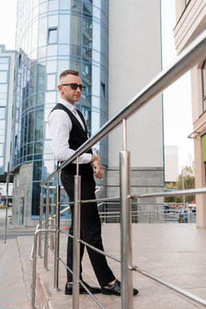 Stylish businessman posing confidently in urban setting.の写真素材