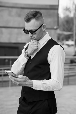 Stylish Man in a Waistcoat Checking His Phone.の写真素材