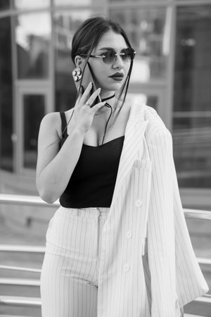 Stylish Young Woman in Impeccable Stripes and Sunglasses Exuding Confidence.の写真素材
