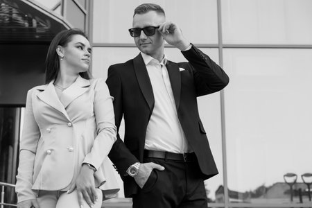 Elegant Couple in Stylish Attire Posing Confidently Outside a Modern Building.の写真素材