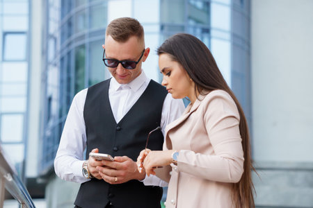 A Stylish Duo Engaged in a Modern Conversation Outdoors.の写真素材