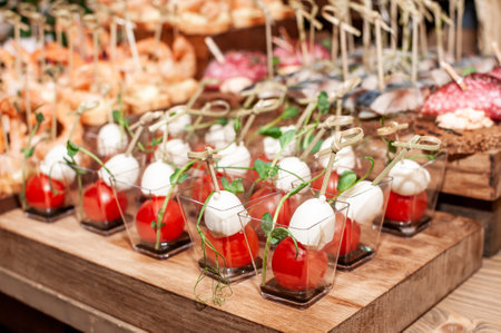 Elegant Display of Appetizing Cherry Tomatoes and Mozzarella in Charming Cups.の写真素材