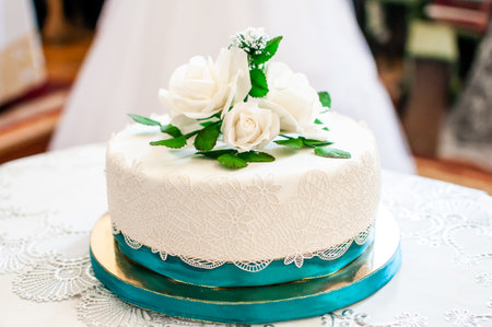 Elegant Wedding Cake Adorned with White Roses and Decorative Lace.の写真素材