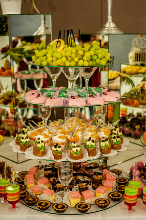 Exquisite Dessert Display with Colorful Treats and Fresh Fruits.の写真素材