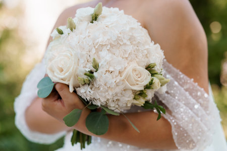 Elegant Bridal Bouquet with Creamy Roses and Hydrangeas in a Soft Natural Setting.