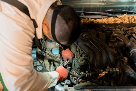 Mechanic Performing Detailed Engine Repair in a Workshop.