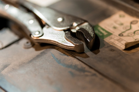 Close-Up of a Silver Adjustable Wrench Resting on a Workshop Table.の写真素材