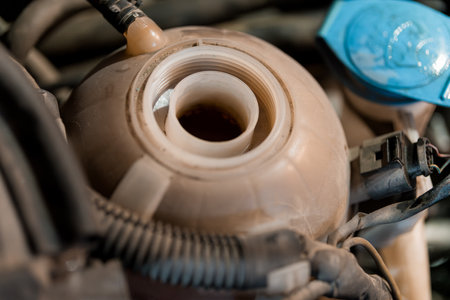 Close-Up View of a Car's Cooling System Reservoir with Fluid Inside.