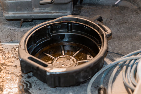 Oil Drain Pan on a Concrete Floor with Various Tools Surrounding It.の写真素材