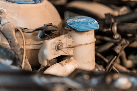 Detailed Close-Up of a Car Engine Component with Blue Cap and Dusty Surroundings.の写真素材