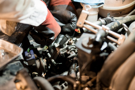 Mechanics Working on an Engine Component in a Dimly Lit Garage.