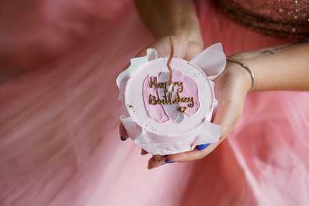 Elegant Birthday Celebration with a Beautiful Cake in a Soft Pink Setting.