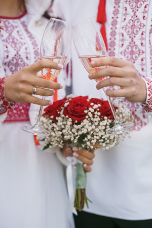 Romantic Wedding Celebration with Traditional Ukrainian Attire and Toasting Glasses.の写真素材