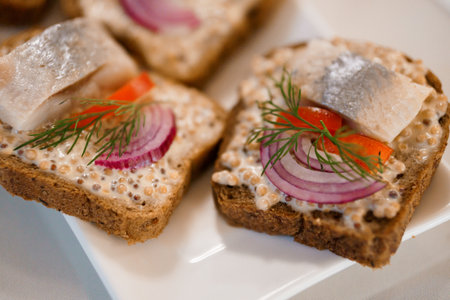 Delicious Open-Faced Sandwiches with Herring, Red Onion, and Fresh Dill on Rye Bread.