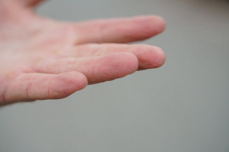 Close-up of a Human Hand with Outstretched Fingers Against a Neutral Background.の写真素材