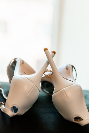 Elegant White High Heels with Wedding Ring on Display.の写真素材