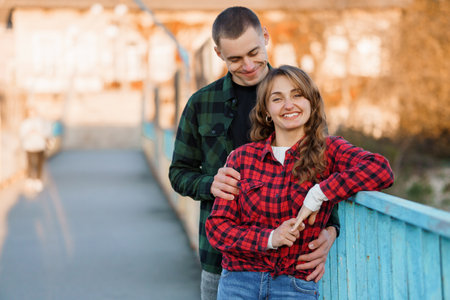 Happy Couple Enjoying a Sunny Day Together on a Colorful Bridge.の写真素材