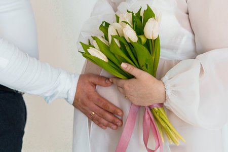 Tender Moment of Expecting Parents with Tulip Bouquet.