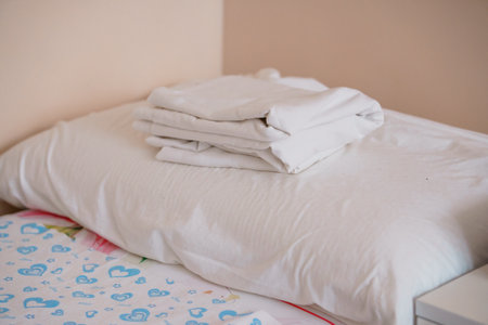 Neatly Folded White Bedding on a Pillow in a Minimalist Bedroom.の写真素材