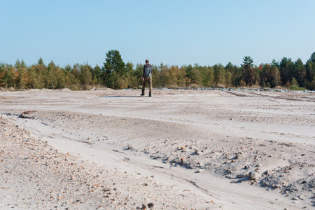 Solitary Figure in a Landscape Surrounded by Sparse Vegetation.の写真素材