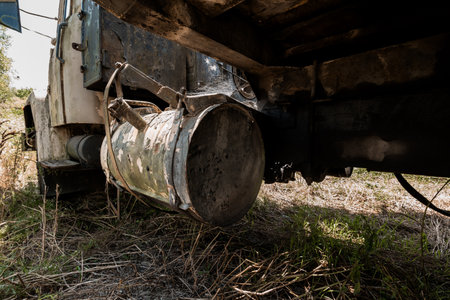 Rusty Vintage Truck with Suspended Drum in Overgrown Grass.の写真素材
