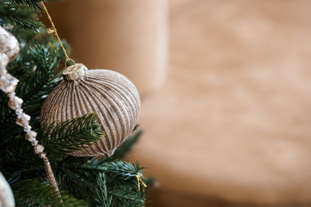 Elegant Gold Christmas Ornament Hanging on a Green Pine Tree.の写真素材