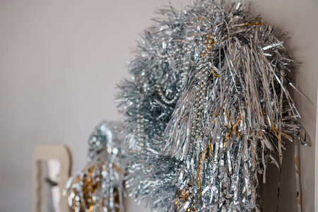 Shimmering Silver and Gold Tinsel Decorations Hanging on a Wall.の写真素材