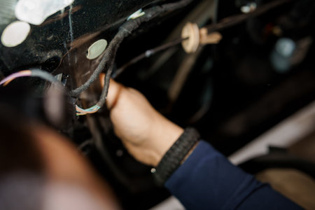Mechanical Repair: Close-Up of a Technician's Hand Working on Vehicle Wiring.の写真素材