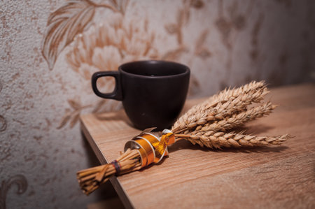 Rustic Still Life with Coffee Cup and Wheat Sheaf on Wooden Table.の写真素材