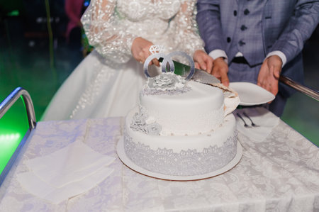 Elegant Wedding Cake Cutting Ceremony with Bride and Groom.の写真素材