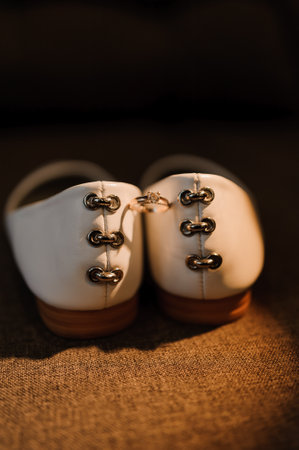 Elegant White Shoes with a Ring on a Backdrop.の写真素材