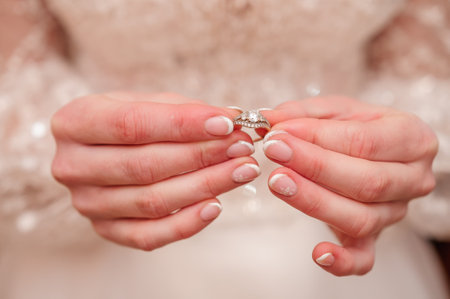Romantic Wedding Ring Close-Up with Delicate Hands.の写真素材
