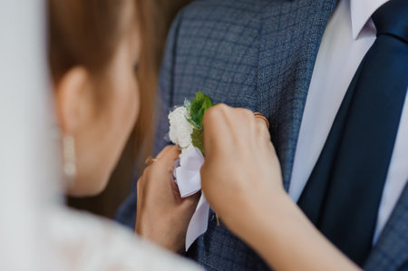 Grooms Attire Adjustment During Wedding Ceremony with Flower Boutonniere.の写真素材