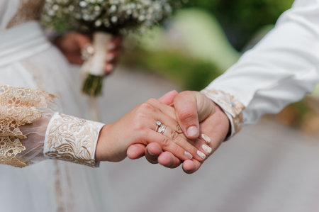 Romantic Wedding Ceremony Handholding with Elegant Floral Arrangement.
