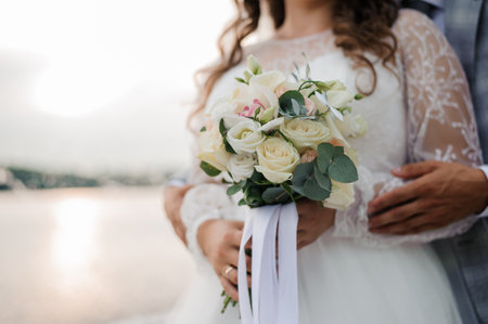 Romantic Outdoor Wedding Bouquet with Bride and Groom by the Water.の写真素材