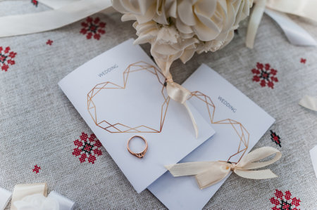 Elegant Wedding Invitation with Rose Gold Ring and Floral Arrangement.の写真素材